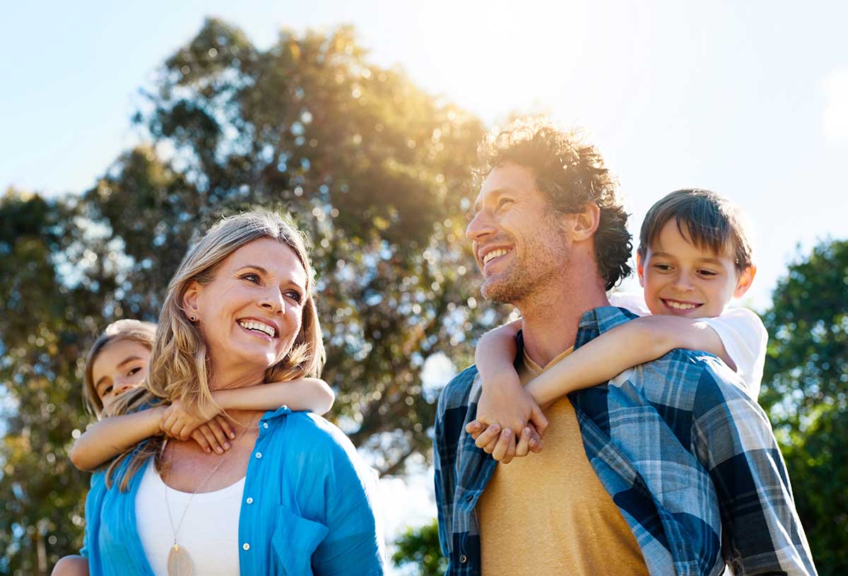 Family, happy and piggyback outdoor with love for bonding, weekend fun and games in nature with sunshine. Parents, kids and carry on back for summer activity, forest scenery or smile on morning walk